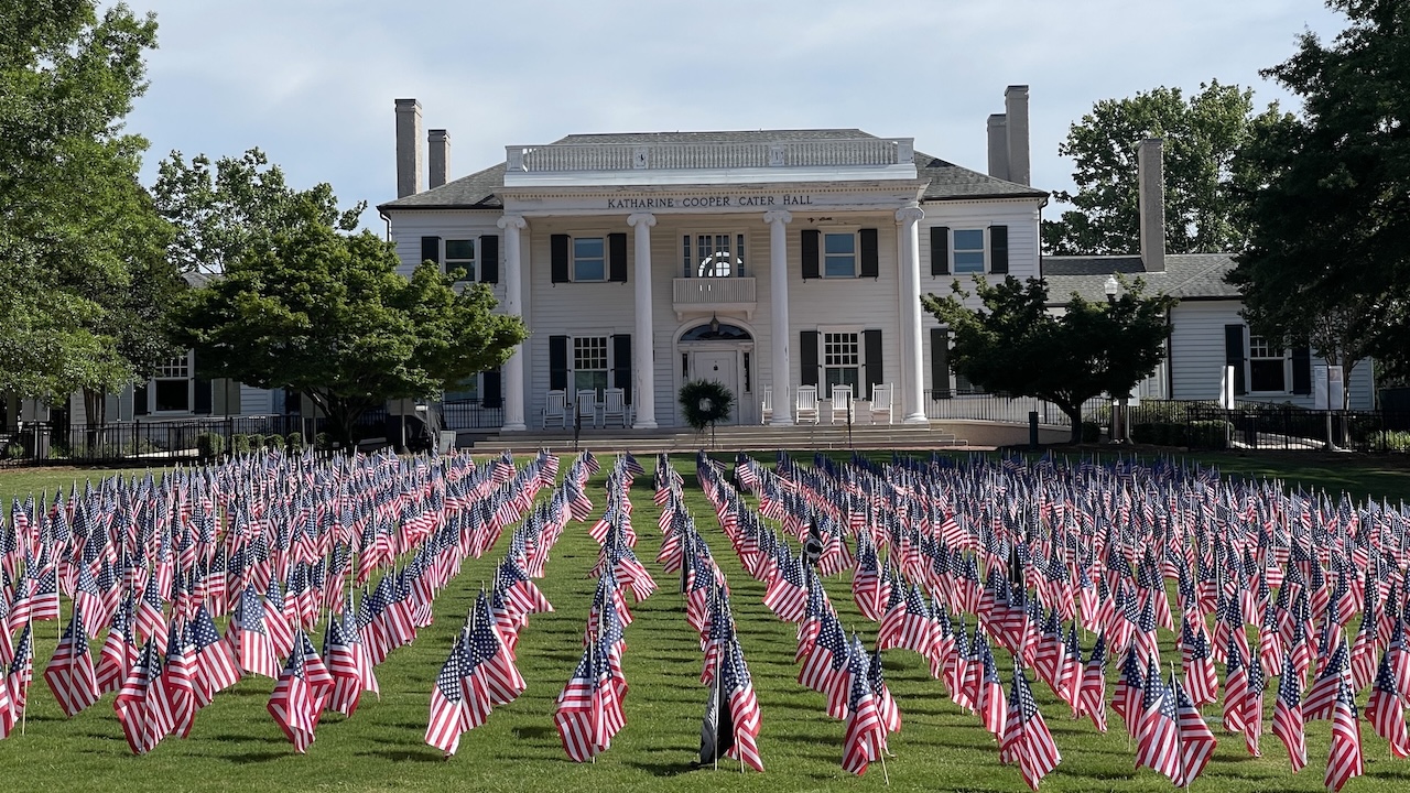 small united states flags on the lawn in front of cater hall