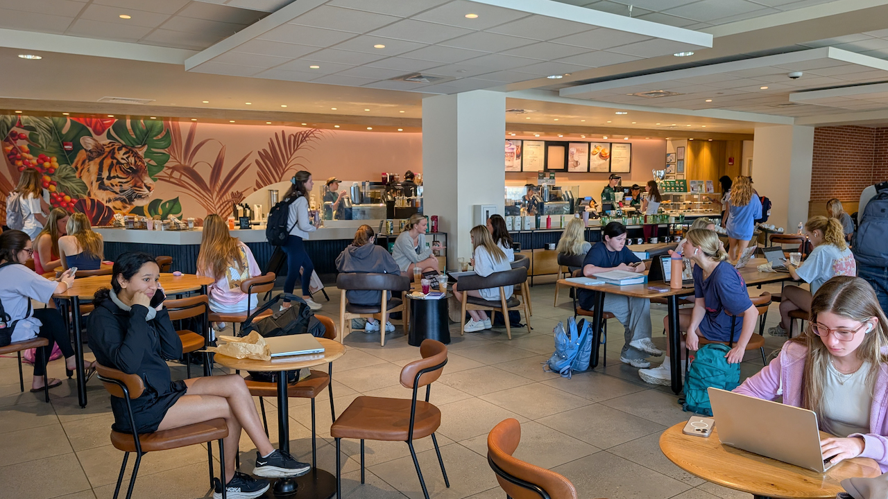students dining and studying at tables inside the Starbucks found in Melton Student Center