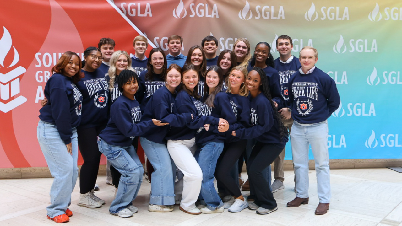 Auburn students posing in front of an SGLA backdrop