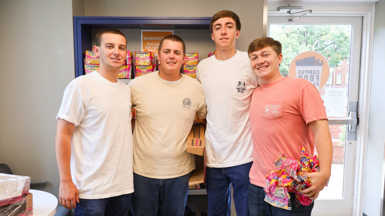 four students smiling at the camera