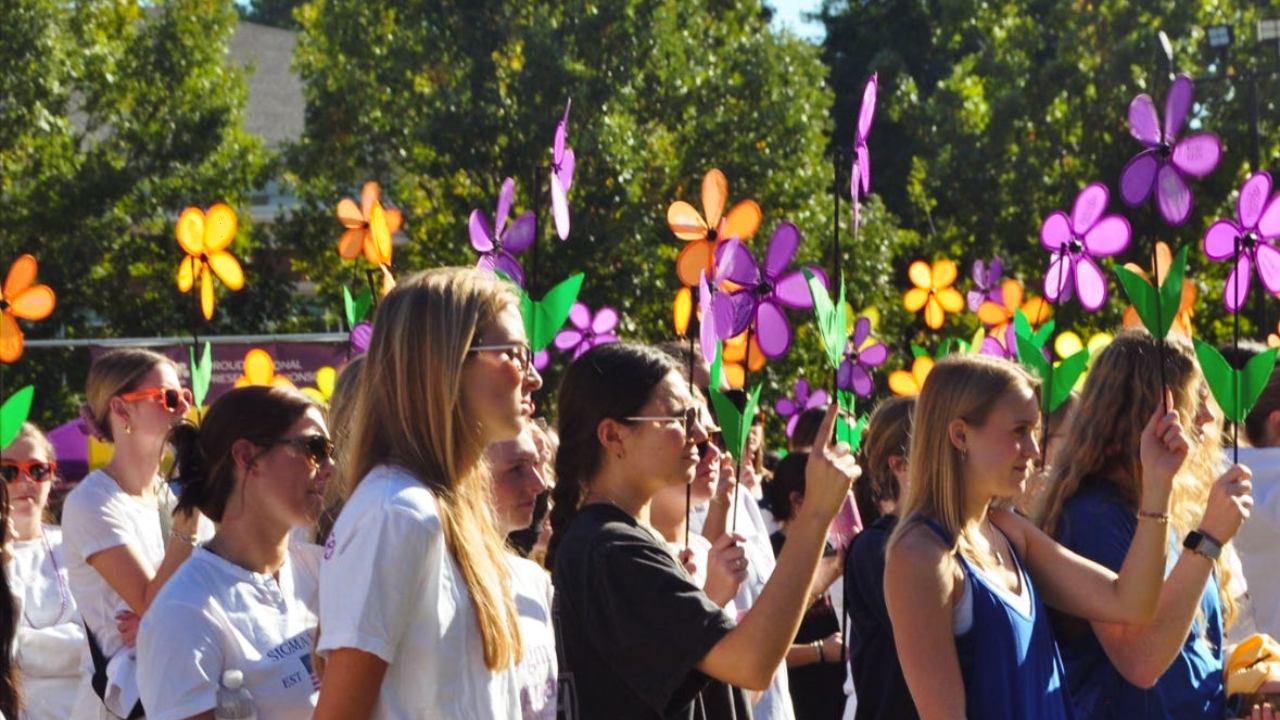 sorority students gather outside walking in a march