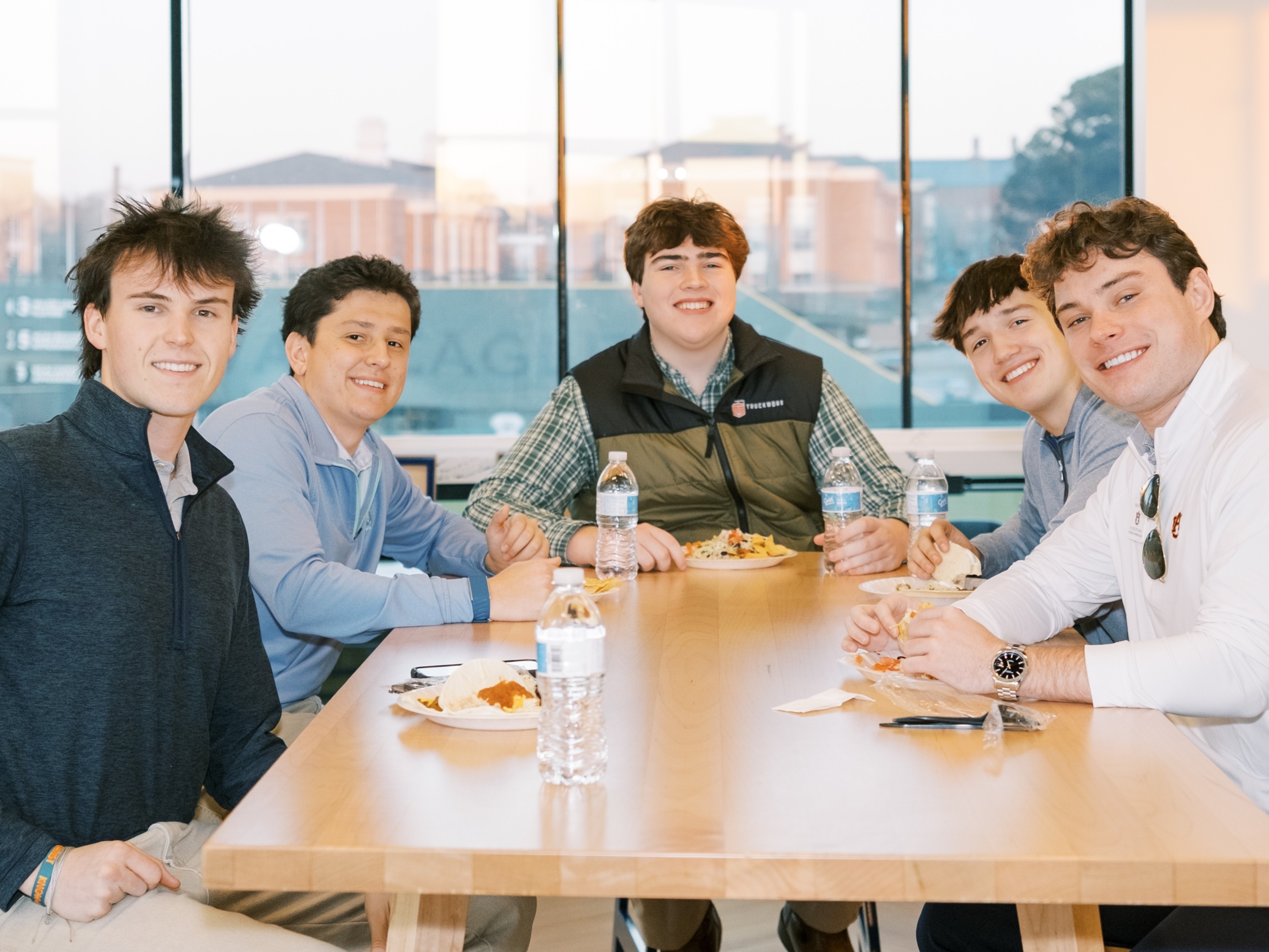 Five men sitting at a table smiling at the camera