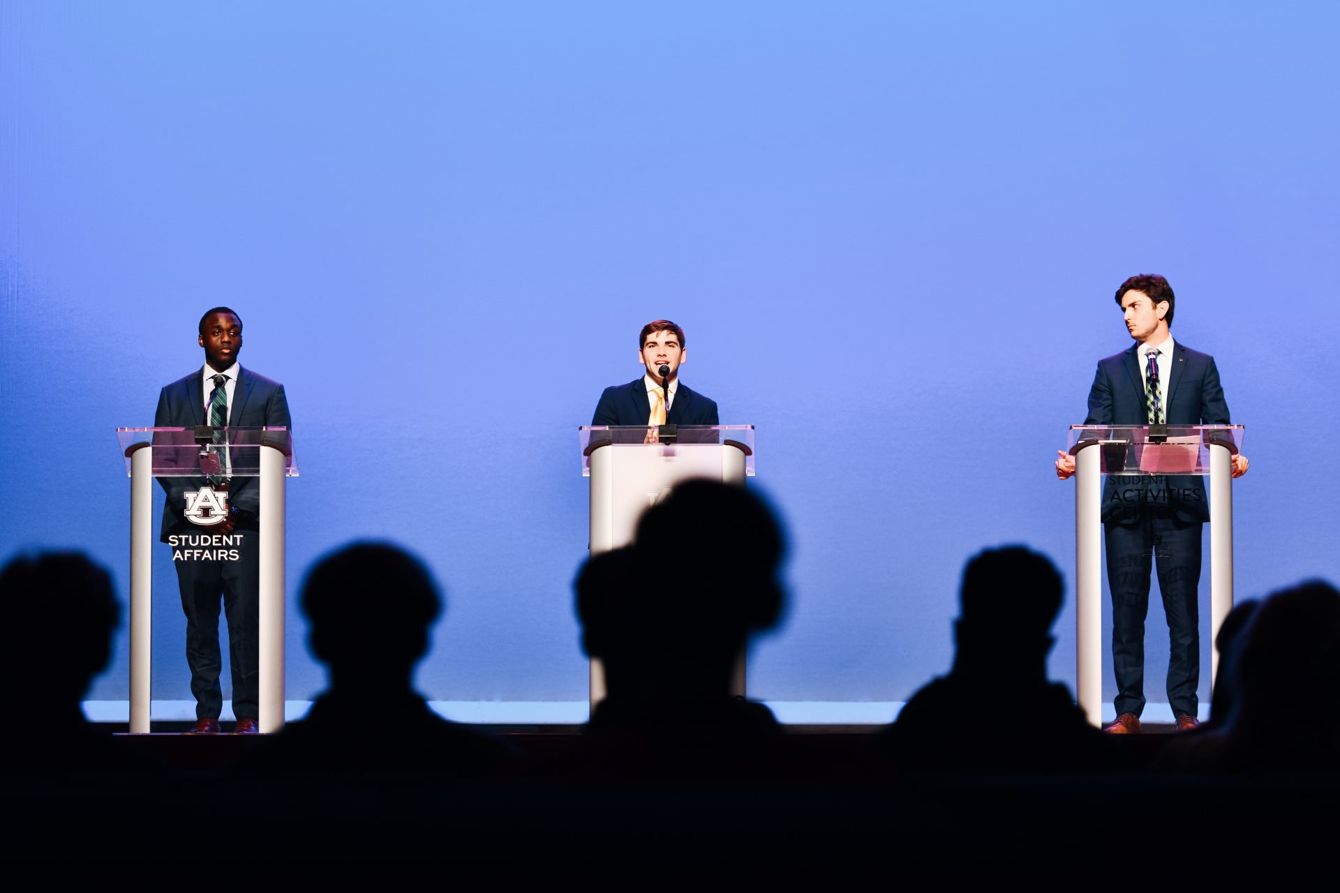 Three SGA candidates on stage at a debate